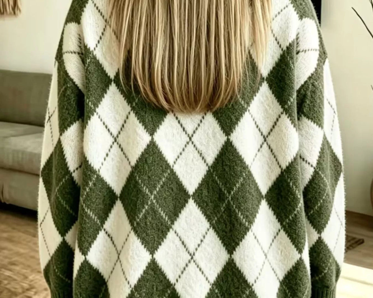 NEWYORKLISTED STYLE COLLECTION: A woman viewed from behind wearing an oversized knit sweater with an olive green and off-white argyle pattern, paired with light blue jeans in a home setting.