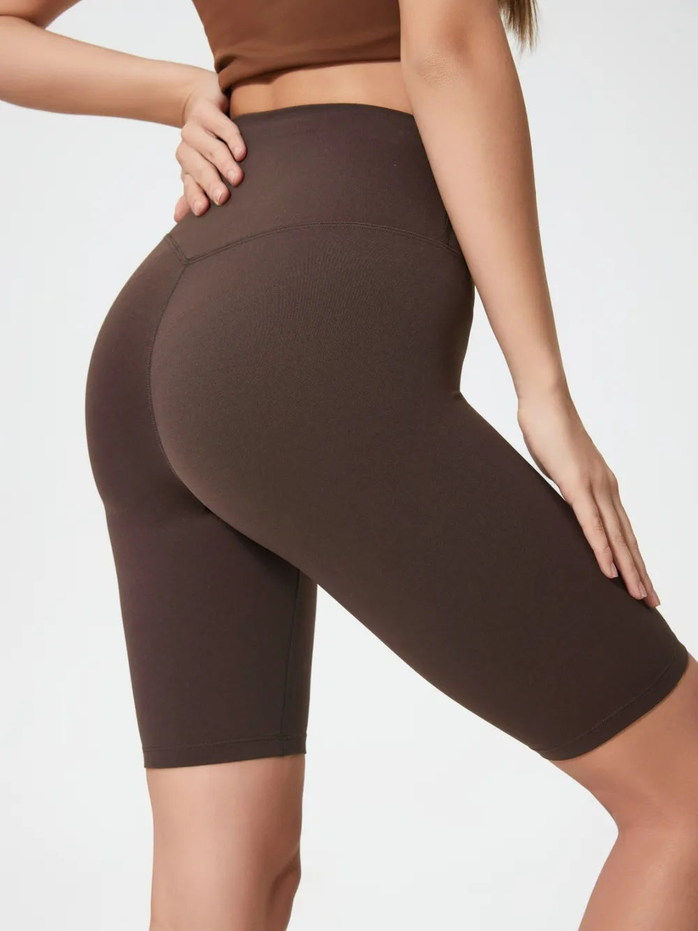Brown athletic shorts worn by a person on a white background