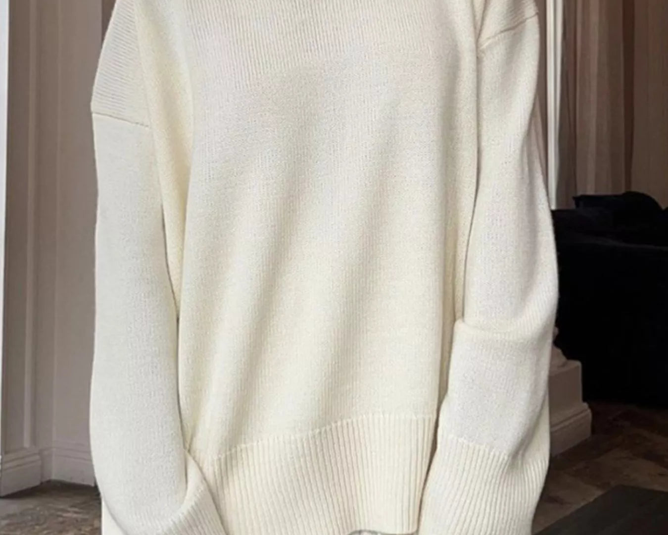 NEWYORKLISTED STYLE COLLECTION: Person wearing a white sweater and pleated skirt indoors.