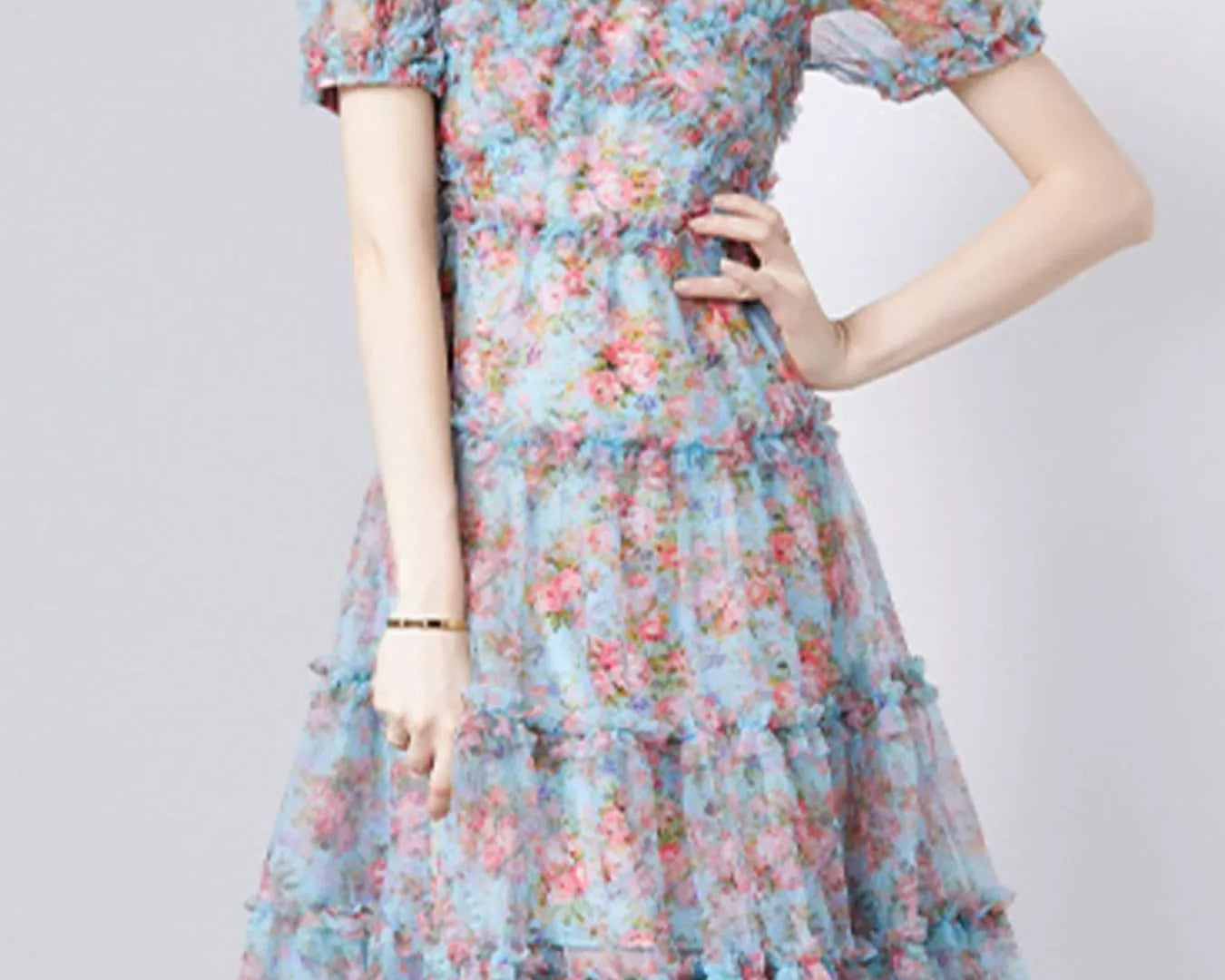 NEWYORKLISTED STYLE COLLECTION: Woman wearing a floral dress on a plain background