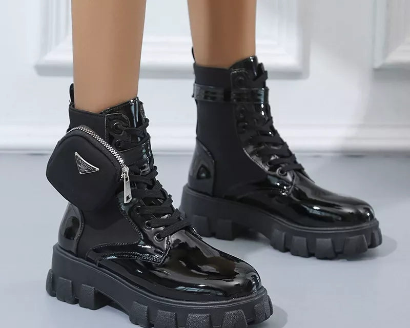 NEWYORKLISTED SHOE COLLECTION: Black patent leather boots with zippers on a neutral background