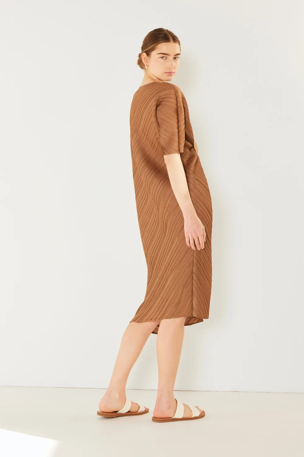 Woman wearing a brown dress against a white background: NEWYORKLISTED STYLE COLLECTION