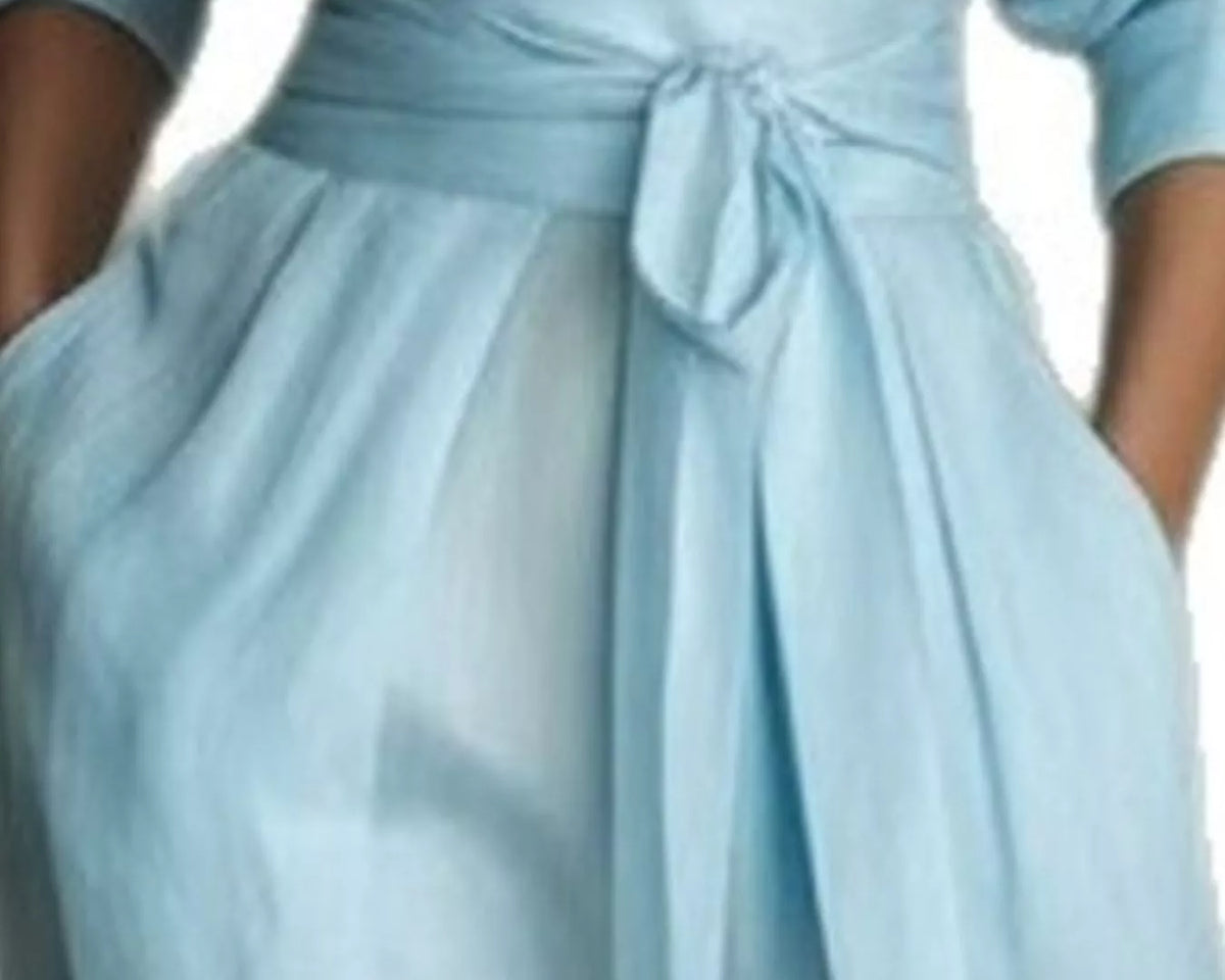 NEWYORKLISTED STYLE COLLECTION: A close-up of a light blue wrap dress with a matching fabric tie belt at the waist, worn by a model.