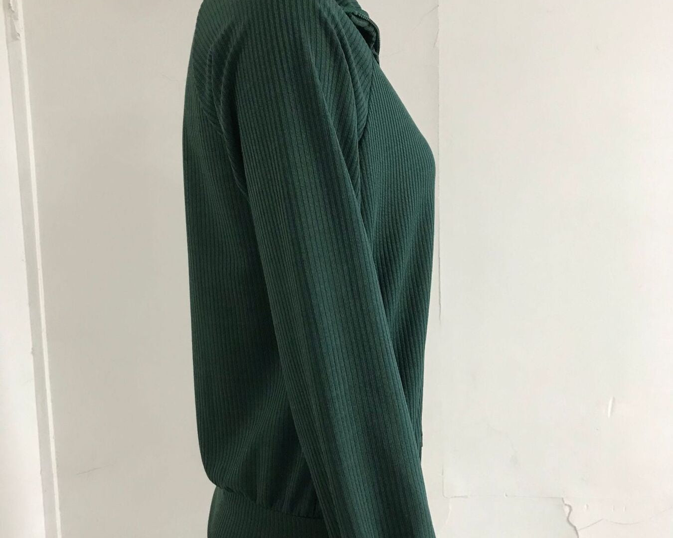 NEWYORKLISTED STYLE COLLECTION: Green ribbed sweater on a mannequin against a white background