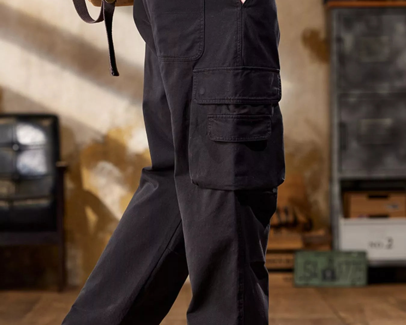NEWYORKLISTED ATLAS MEN's COLLECTION: Person wearing dark cargo pants with a backpack indoors