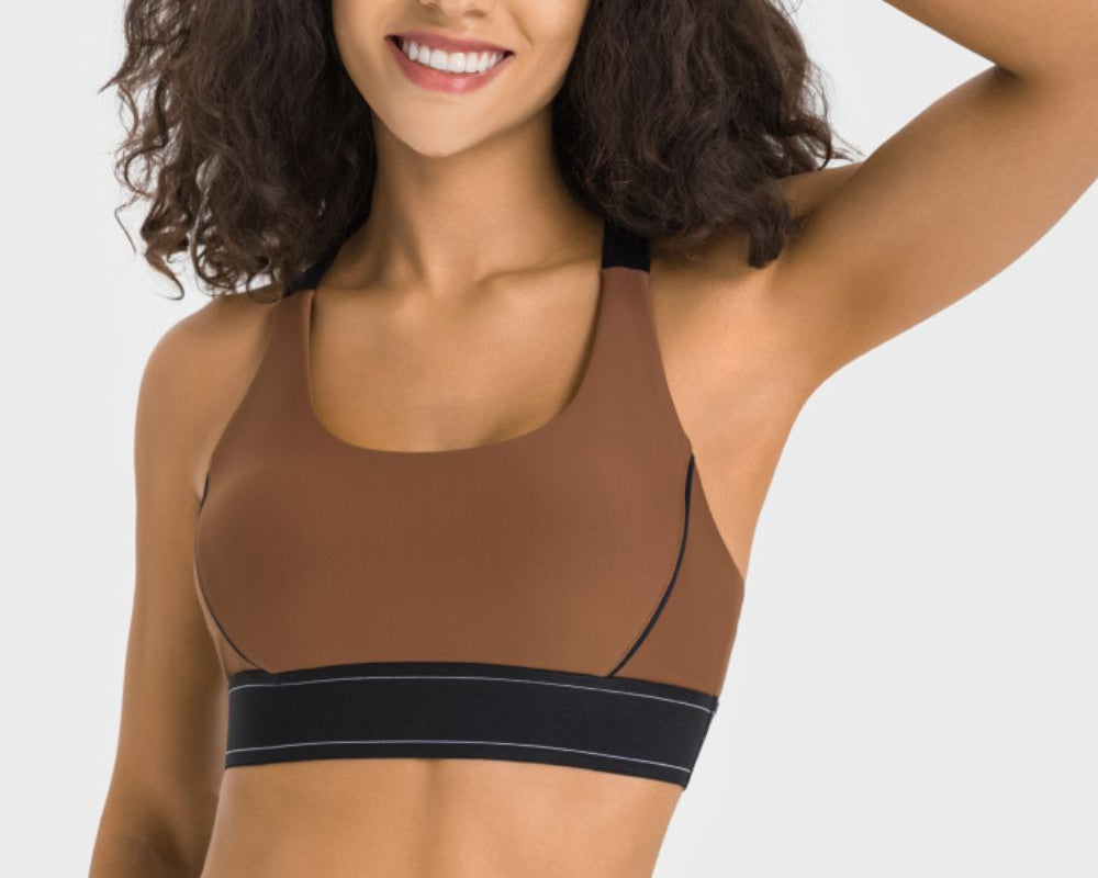 NEWYORKLISTED ACTIVEWEAR COLLECTION: Woman wearing a brown sports bra and leggings on a white background