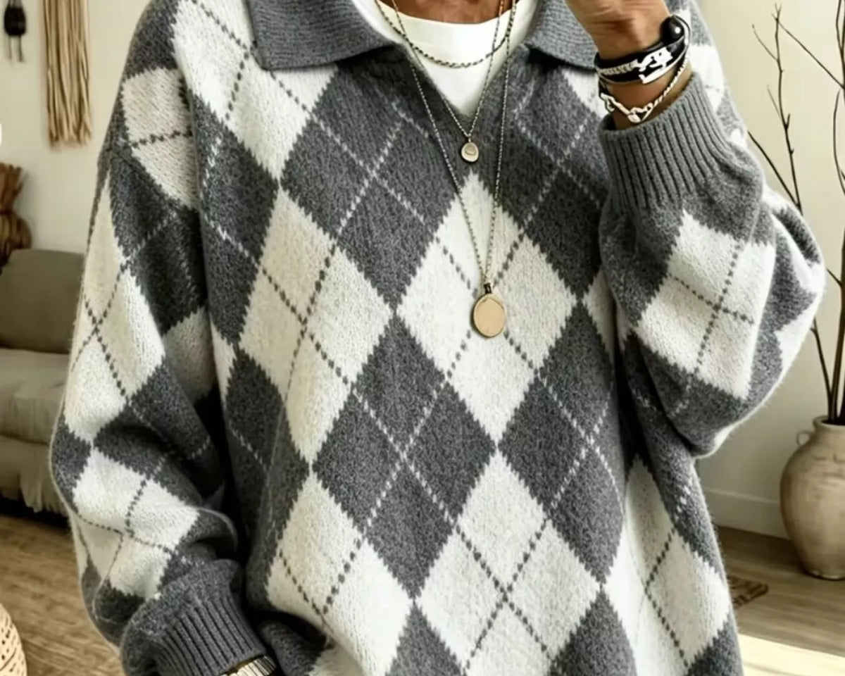 NEWYORKLISTED STYLE COLLECTION: A woman takes a mirror selfie wearing a cozy oversized knit sweater with a gray and white argyle pattern, layered over a white t-shirt and paired with light-wash jeans.