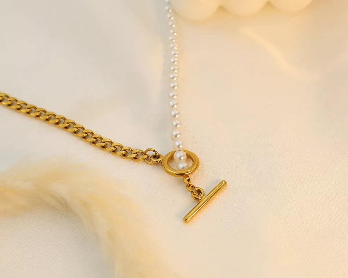 NYLD Glamour Collection by NEWYORKLISTED: Gold necklace with a chain and clasp on a soft beige background