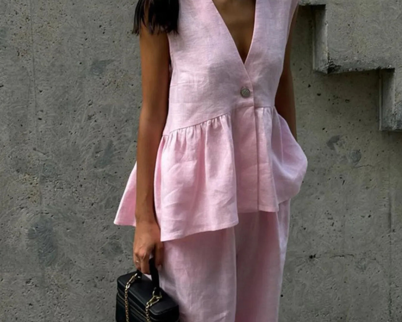NEWYORKLISTED female model wearing a pink outfit against a gray wall