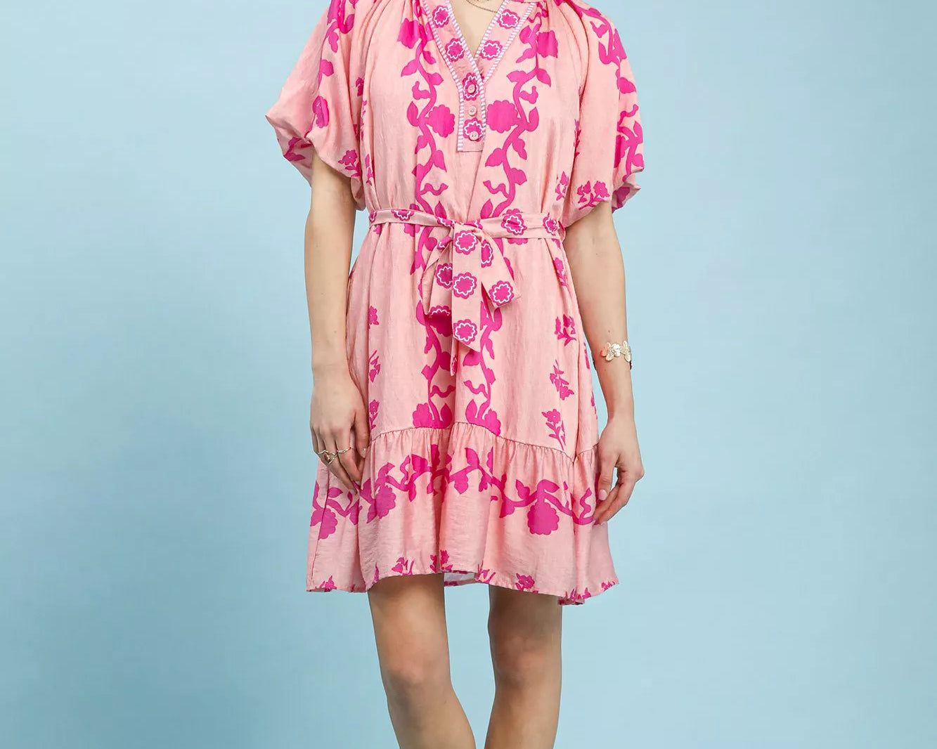 NEWYORKLISTED STYLE COLLECTION: Woman wearing a pink floral dress against a light blue background