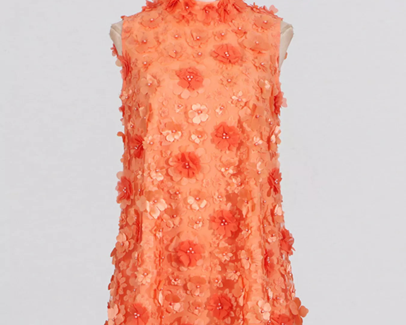 NEWYORKLISTED STYLE COLLECTION: Coral floral dress on a mannequin against a light gray background