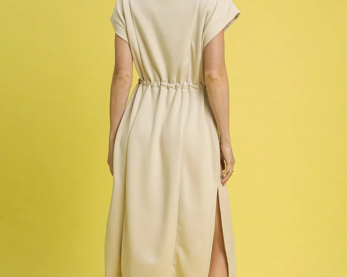 NEWYORKLISTED STYLE COLLECTION: Short Sleeve Midi Tee Dress: Woman wearing a beige dress with a yellow background