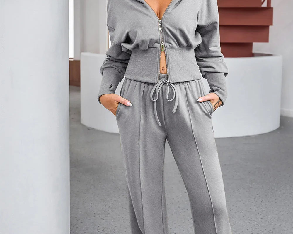 NEWYORKLISTED ACTIVEWEAR COLLECTION: Woman wearing a gray tracksuit in an indoor setting