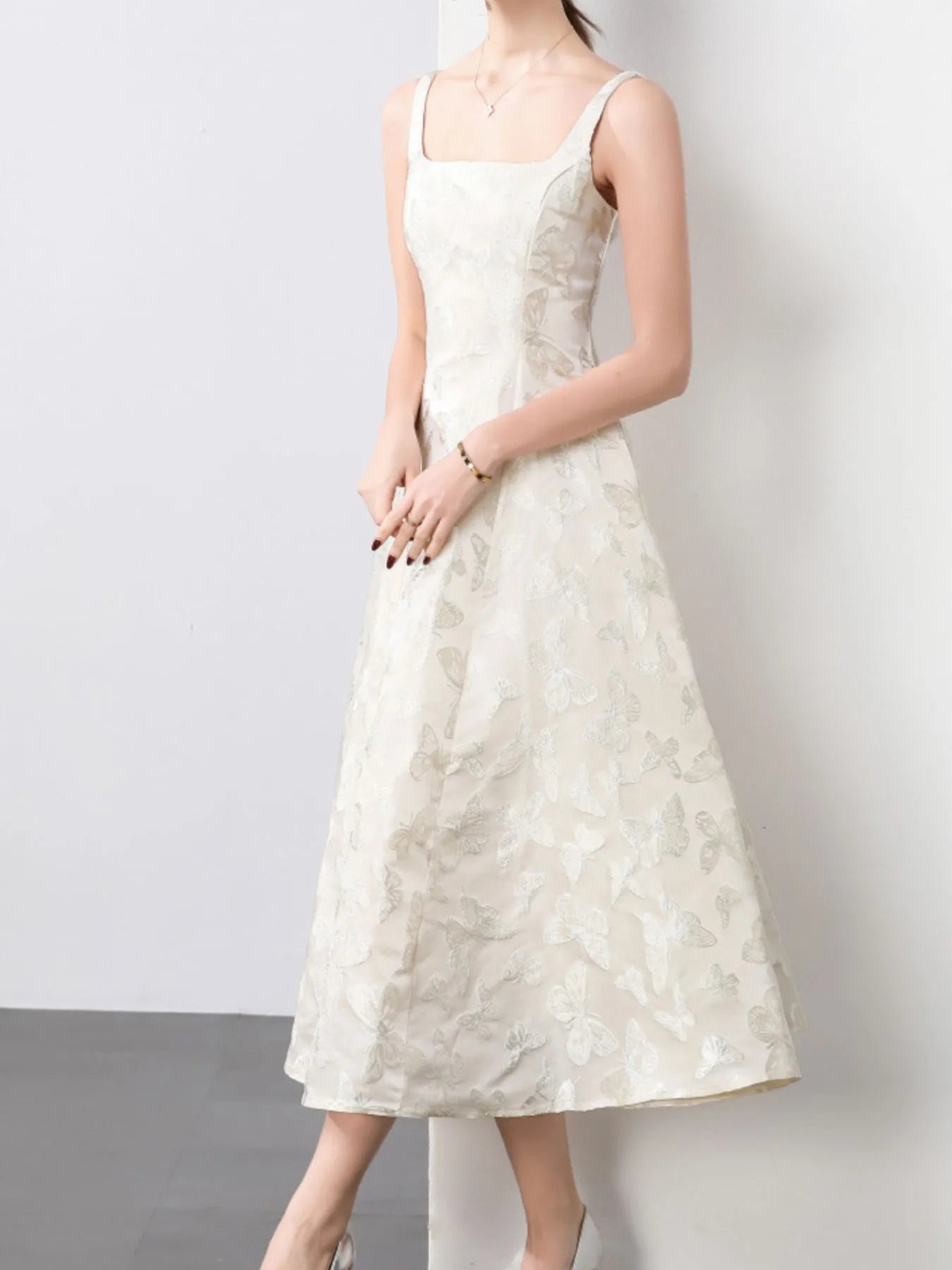 NEWYORKLISTED STYLE COLLECTION: Woman wearing a white floral dress against a plain background