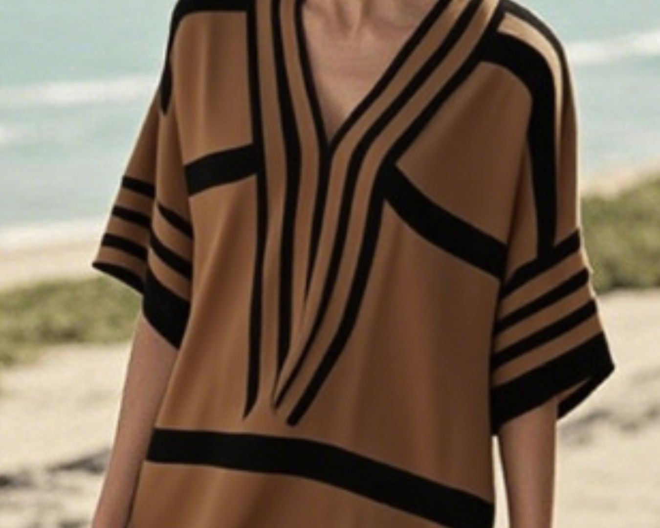 NEWYORKLISTED STYLE COLLECTION: Woman wearing a brown and black striped dress on a beach.