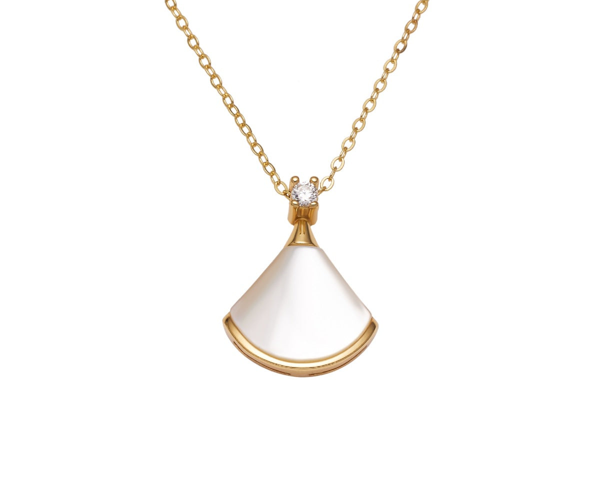NYLD Glamour By NEWYORKLISTED: Gold necklace with a white pendant on a white background