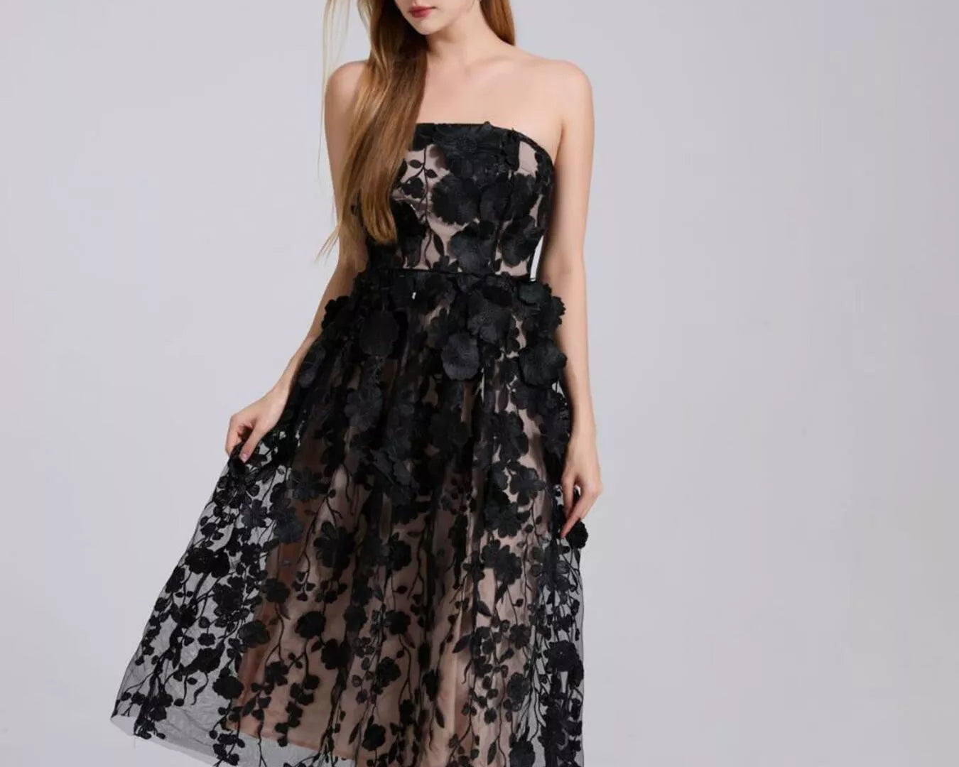 NEWYORKLISTED STYLE COLLECTION: Woman wearing a black floral dress on a gray background