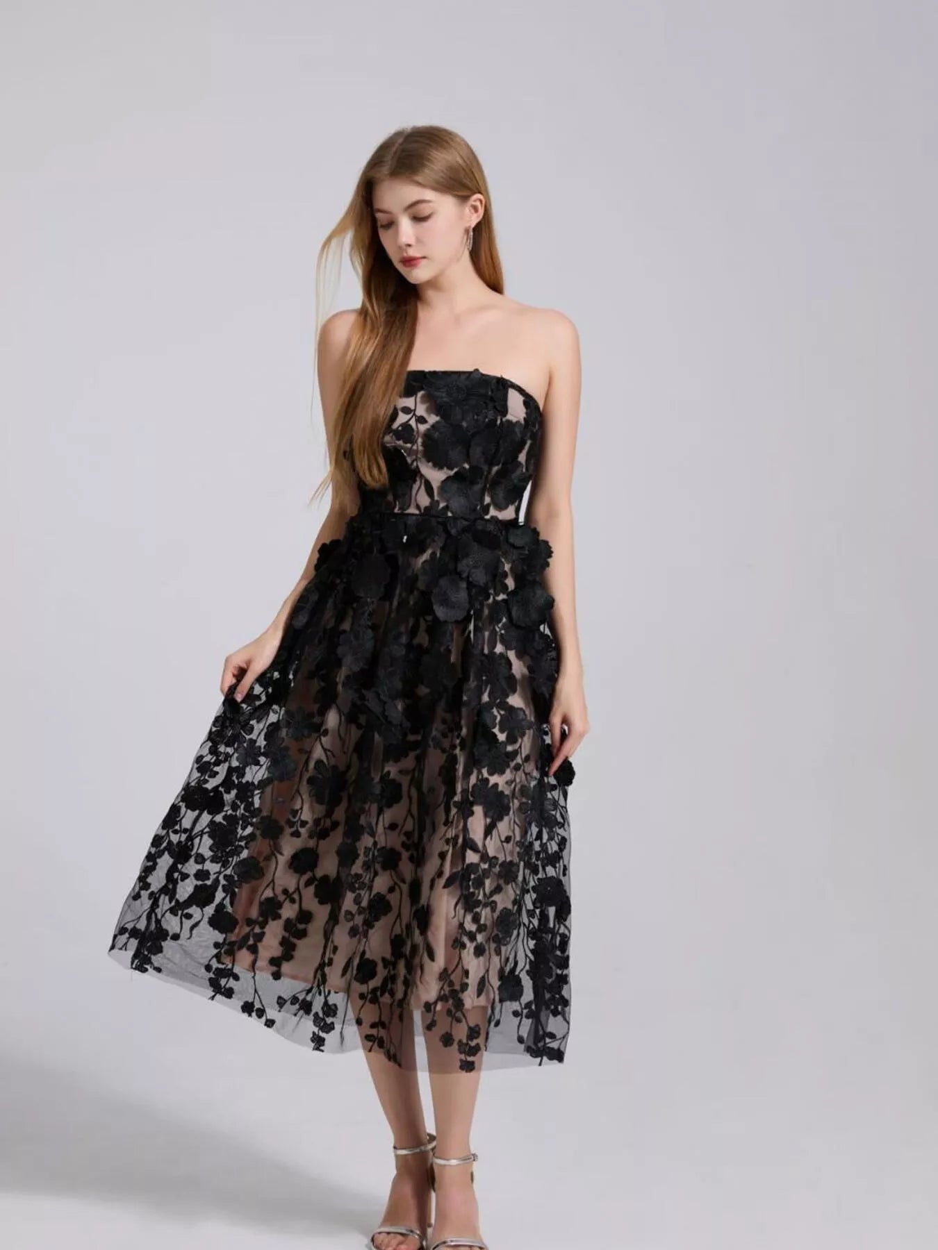 NEWYORKLISTED STYLE COLLECTION: Woman wearing a black floral dress on a gray background