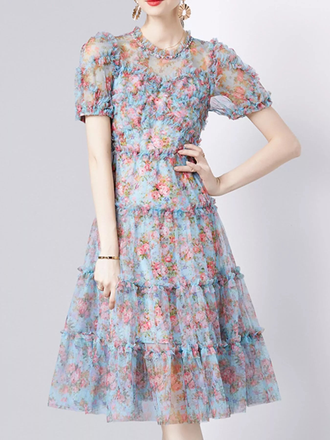 NEWYORKLISTED STYLE COLLECTION: Woman wearing a floral dress on a plain background