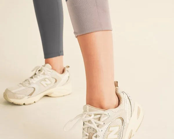 NEWYORKLISTED ACTIVEWEAR Person wearing light-colored sneakers and gray leggings on a neutral background showing the fleece lining on the leggings