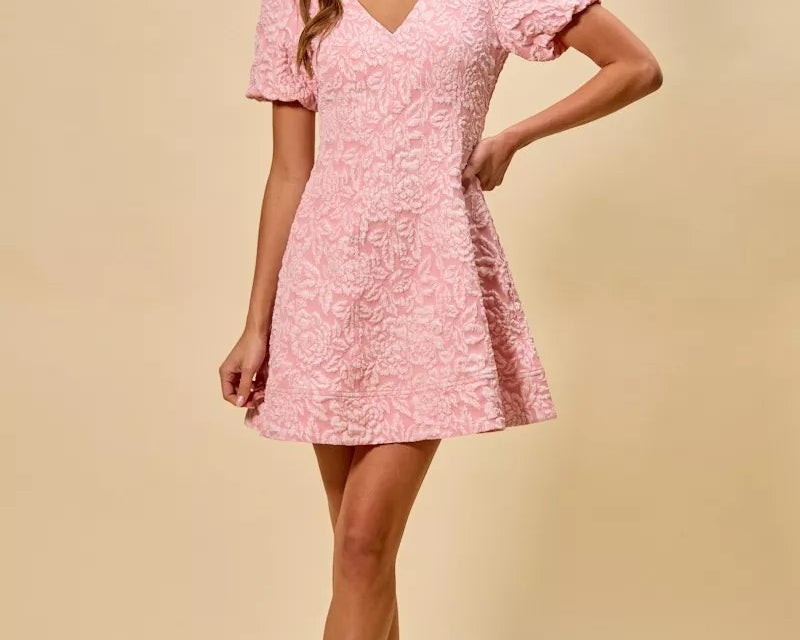 NEWYORKLISTED STYLE COLLECTION: Woman wearing a pink lace dress against a beige background