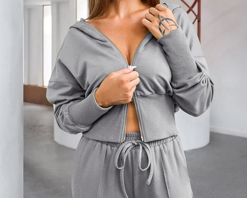 NEWYORKLISTED ACTIVEWEAR COLLECTION: Woman wearing a gray tracksuit in an indoor setting
