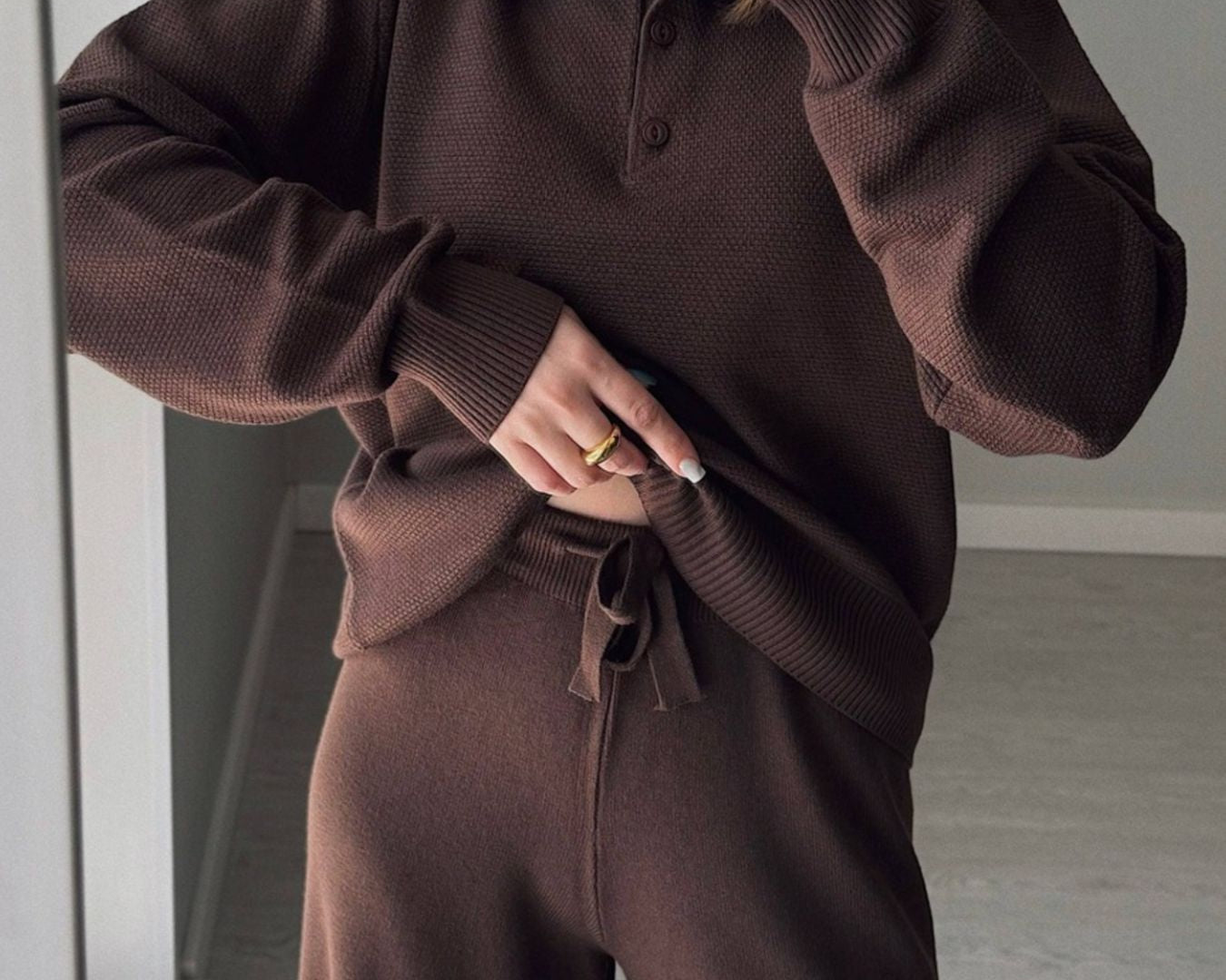 NEWYORKLISTED Comfort Collection: Person wearing a brown knit outfit taking a mirror selfie.