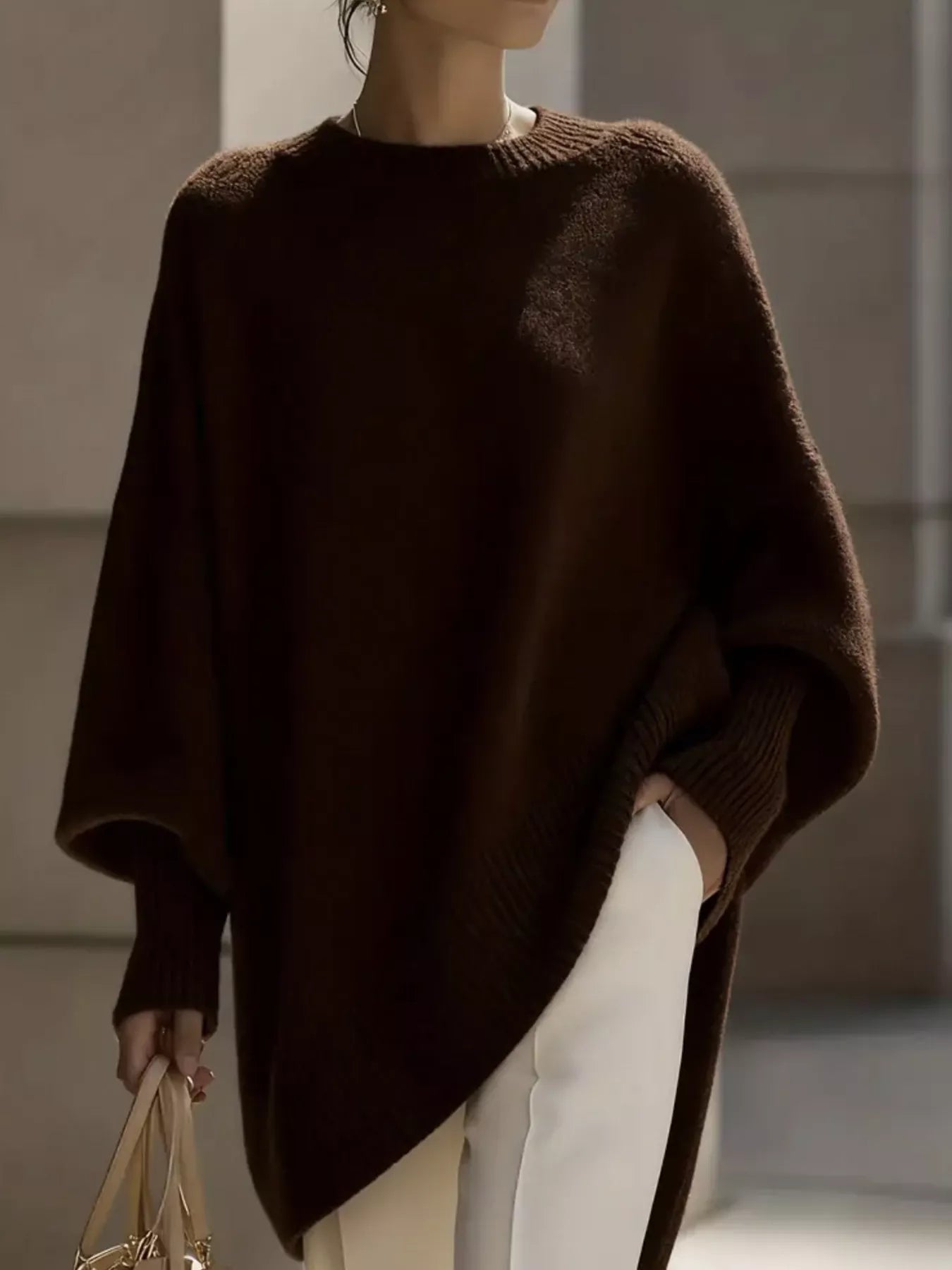 NEWYORKLISTED STYLE COLLECTION: Person wearing a brown poncho with a neutral background