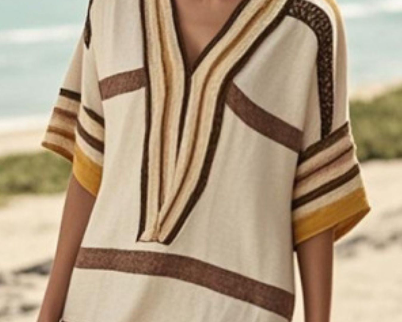 NEWYORKLISTED STYLE COLLECTION: Woman wearing a striped cover-up on a beach