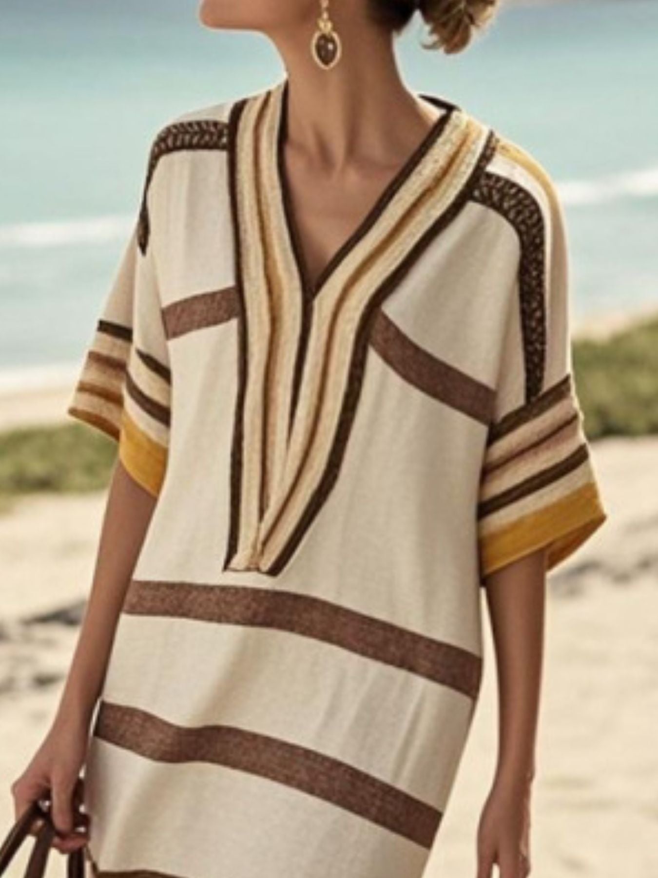 NEWYORKLISTED STYLE COLLECTION: Woman wearing a striped cover-up on a beach