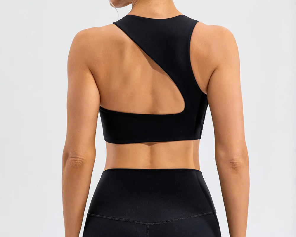 NEWYORKLISTED ACTIVEWEAR COLLECTION: Person wearing a black sports bra and leggings on a light gray background