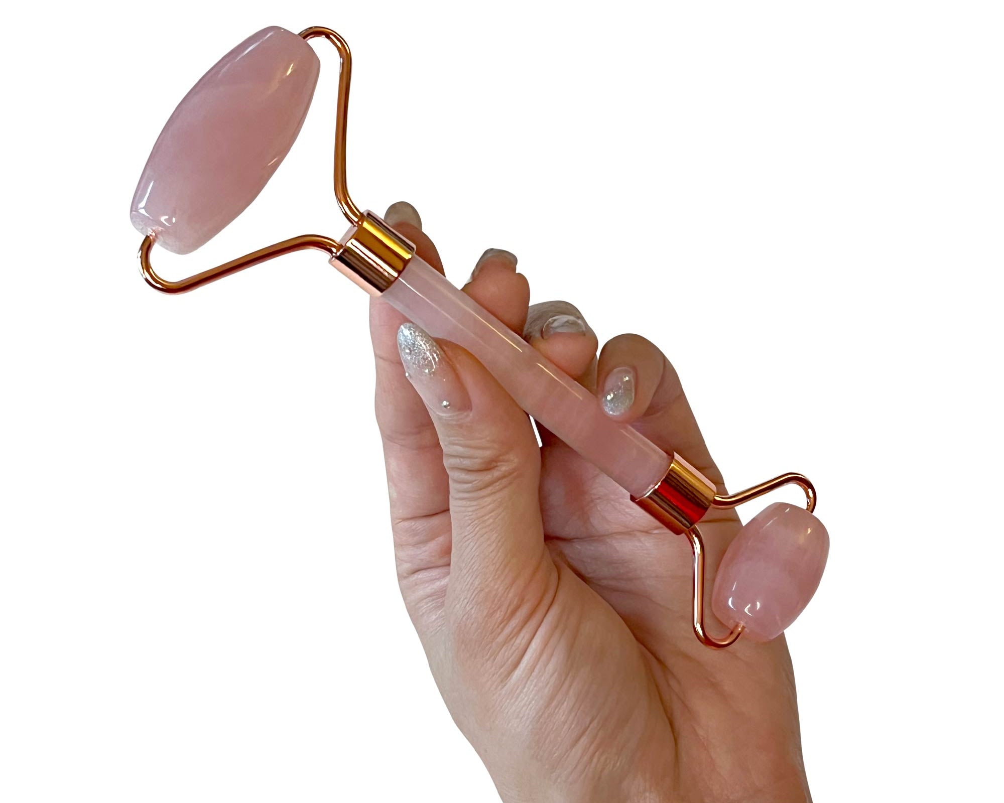 NEWYORKLISTED Cosmetic Collection: Hand holding a pink and gold facial roller against a white background