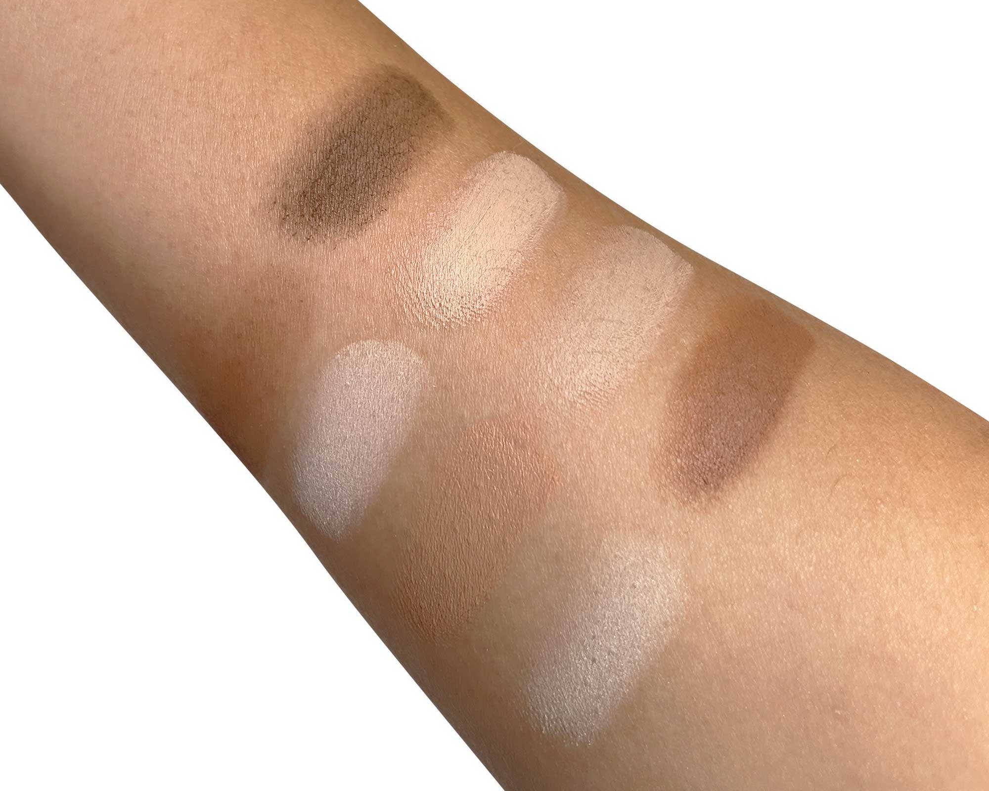 NEWYORKLISTED Cosmetic Collection: Ultimate Contour Color swatches on a person's arm with various shades of brown and beige.