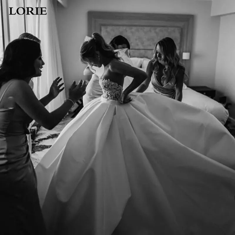 Black and white photo of a bride getting ready with friends in a hotel room.