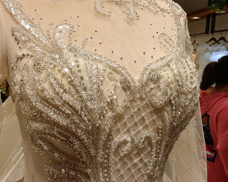 Close-up of a beaded and embroidered dress on a mannequin with a blurred background