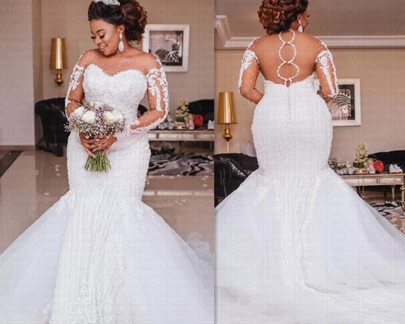Woman in a white wedding dress holding flowers in a decorated room.