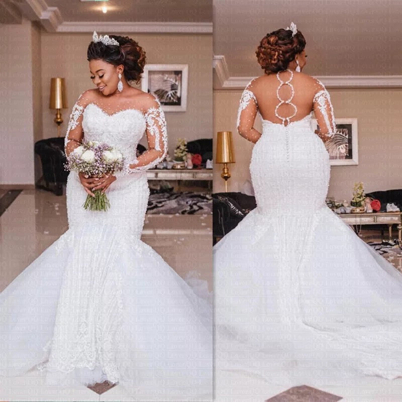 Woman in a white wedding dress holding flowers in a decorated room.