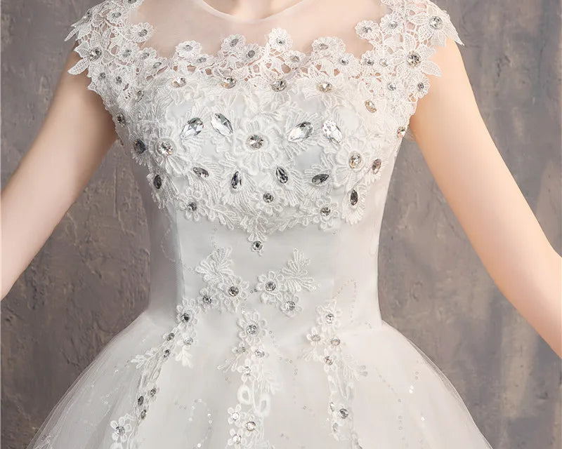 White lace dress with floral and crystal details on a neutral background