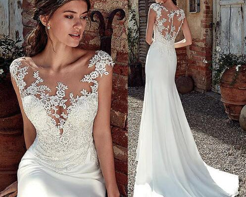 Woman wearing a white lace wedding dress in an outdoor setting.