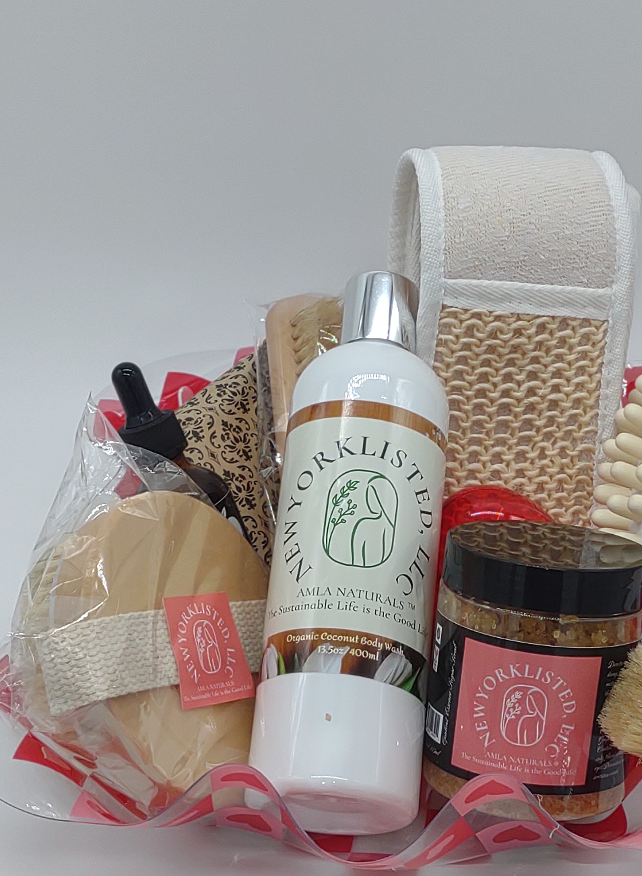 NEWYORKLISTED Valentine’s Day Luxury Spa Gift Basket, Set of grooming products including a bottle, brush, and other items on a white background