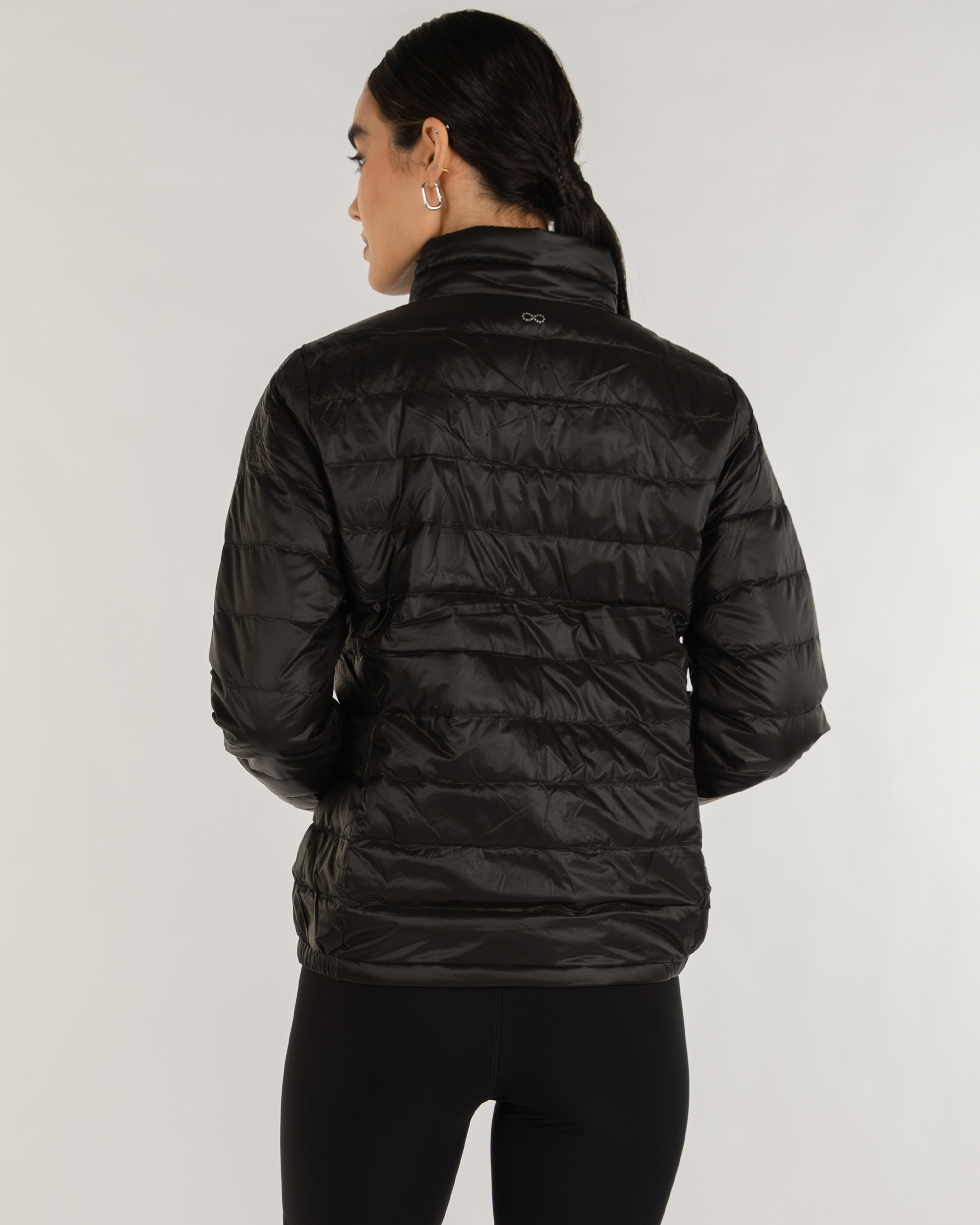 Person wearing a black puffer jacket on a white background
