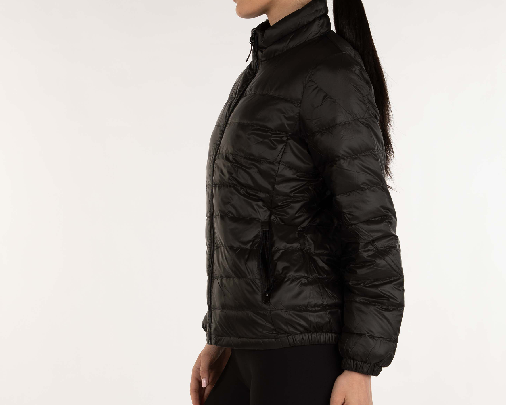 Woman wearing a black puffer jacket on a white background