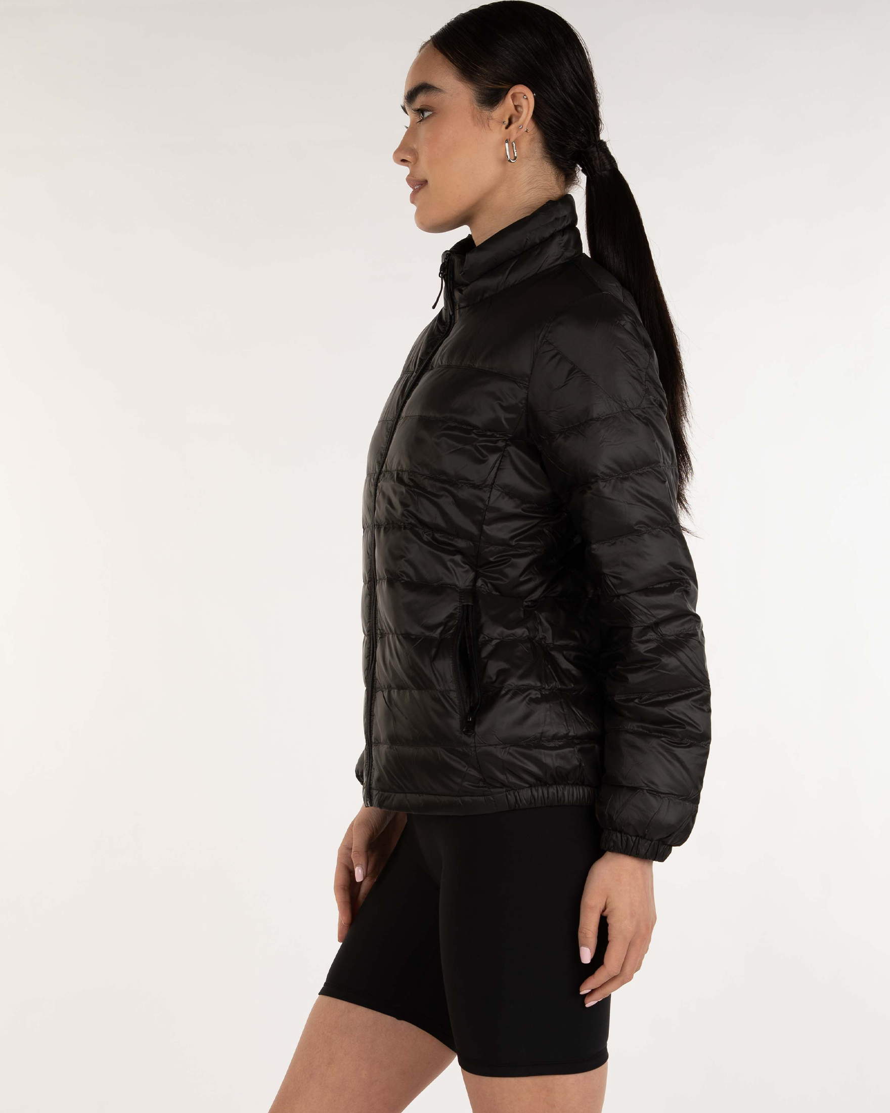 Woman wearing a black puffer jacket on a white background