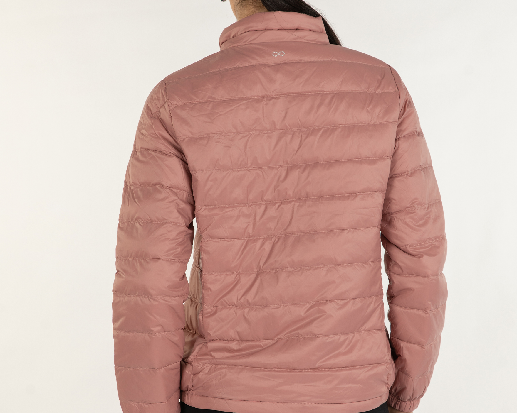 Person wearing a pink puffer jacket on a white background