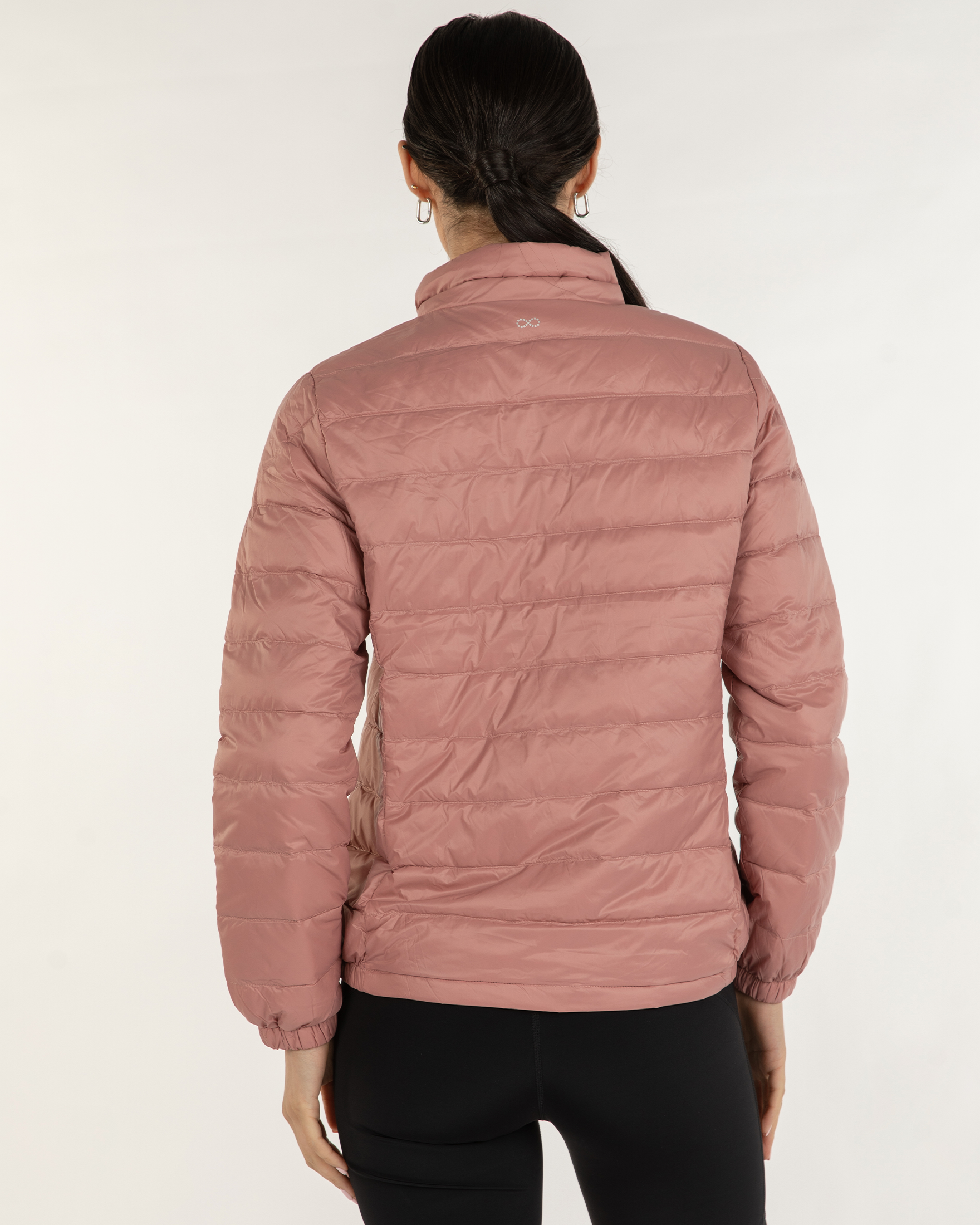 Person wearing a pink puffer jacket on a white background