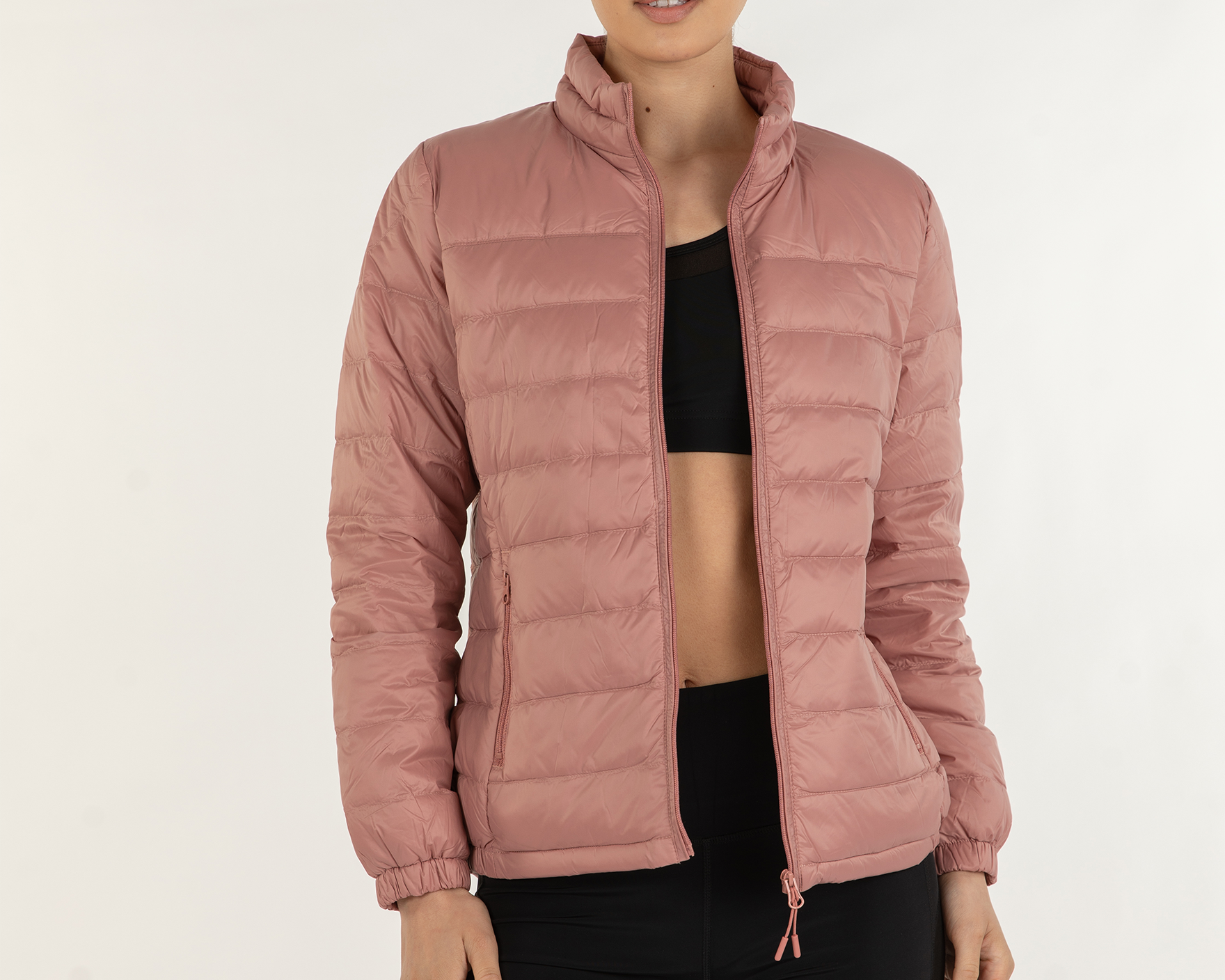 NEWYORKLISTED STYLE COLLECTION: Person wearing a pink puffer jacket on a white background in rose