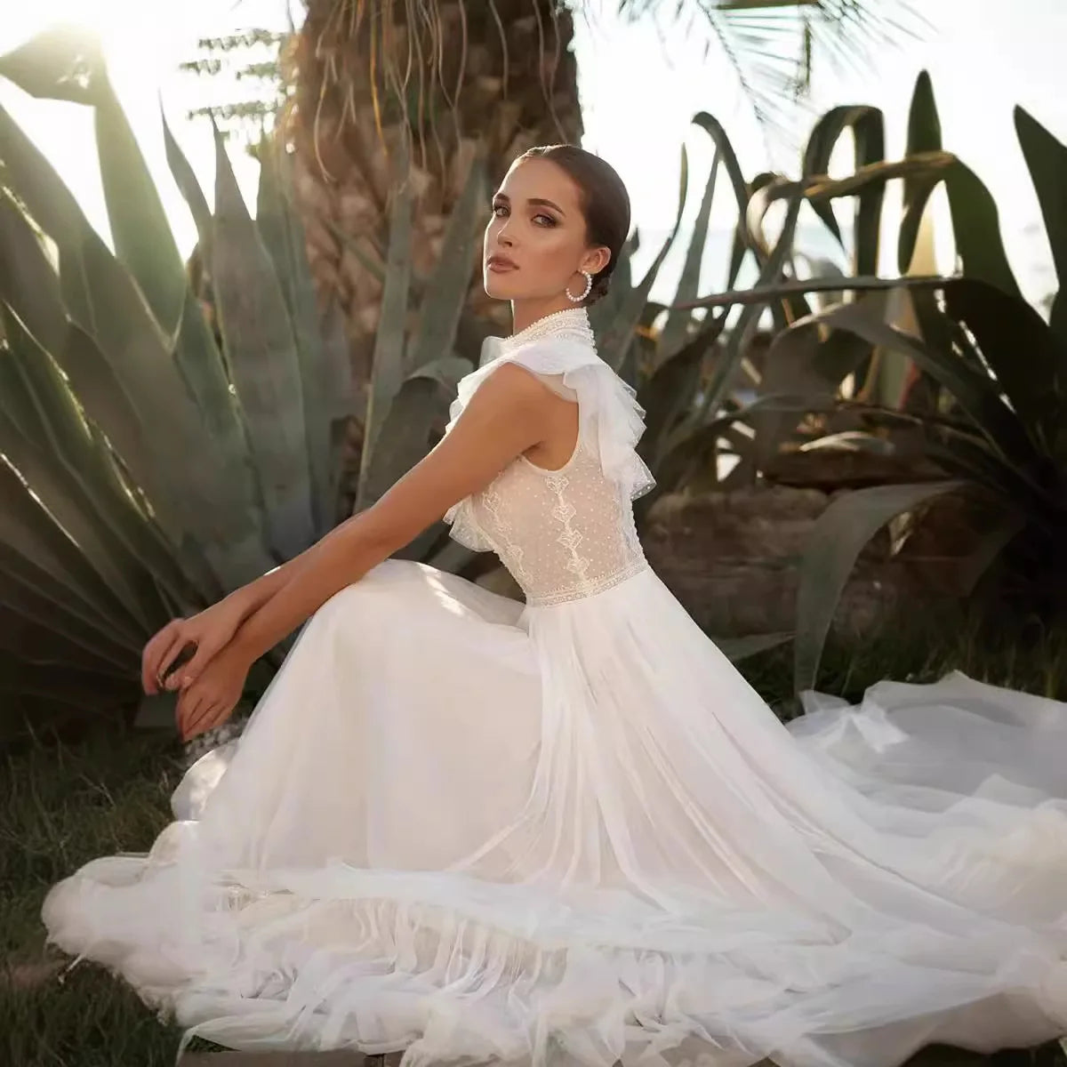 Woman in a white dress sitting among plants with a warm glow