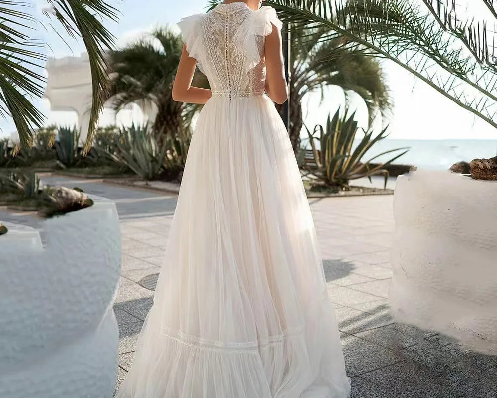 Woman in a white dress standing in a tropical setting with palm trees and a clear sky.