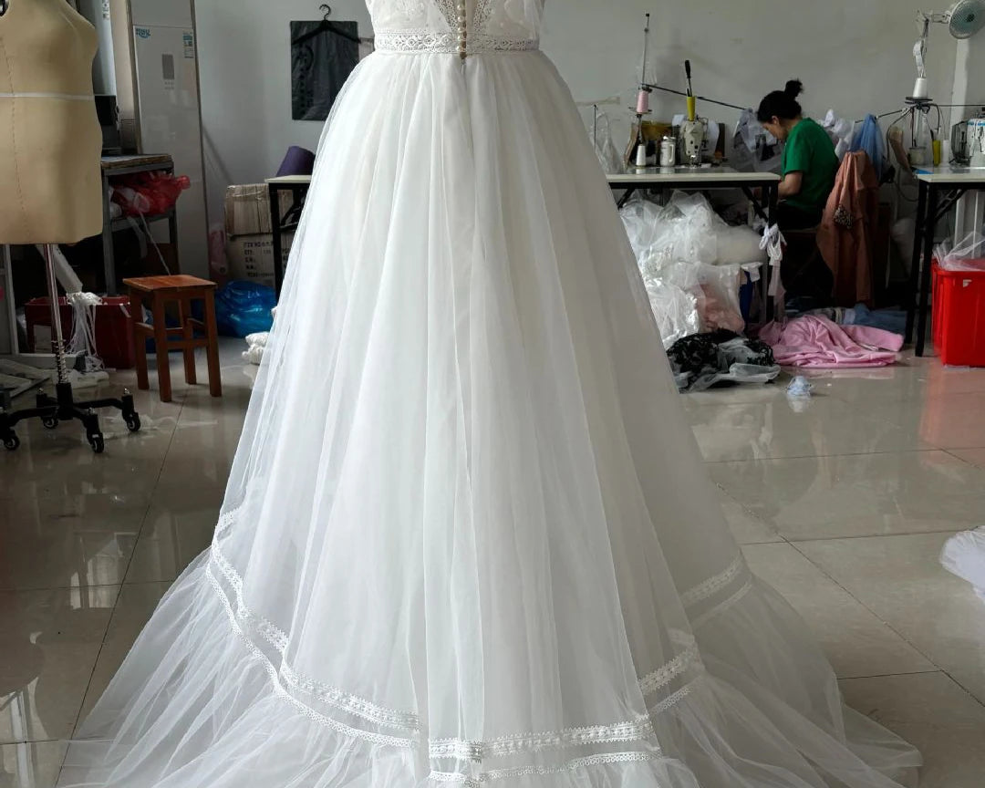 White wedding dress on a mannequin in a workshop setting