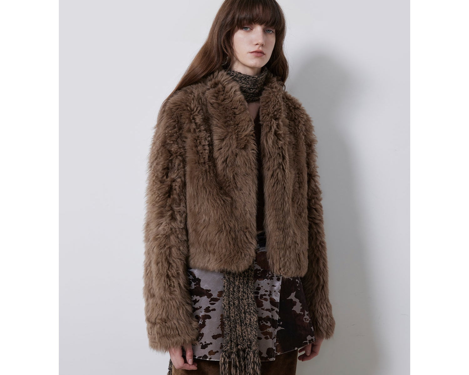 NEWYORKLISTED STYLE COLLECTION: Woman wearing a brown fur coat with a plain background